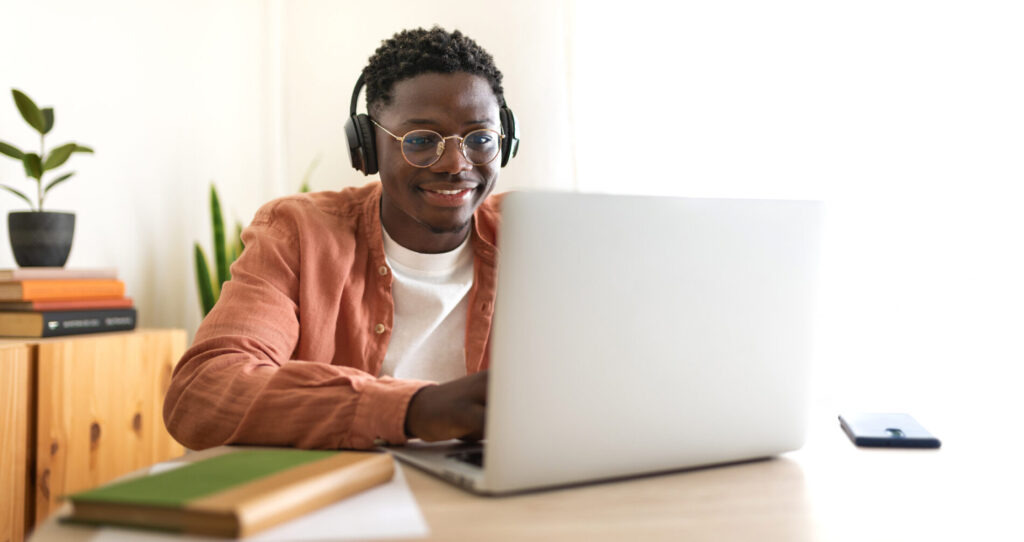man with headphones on laptop at home